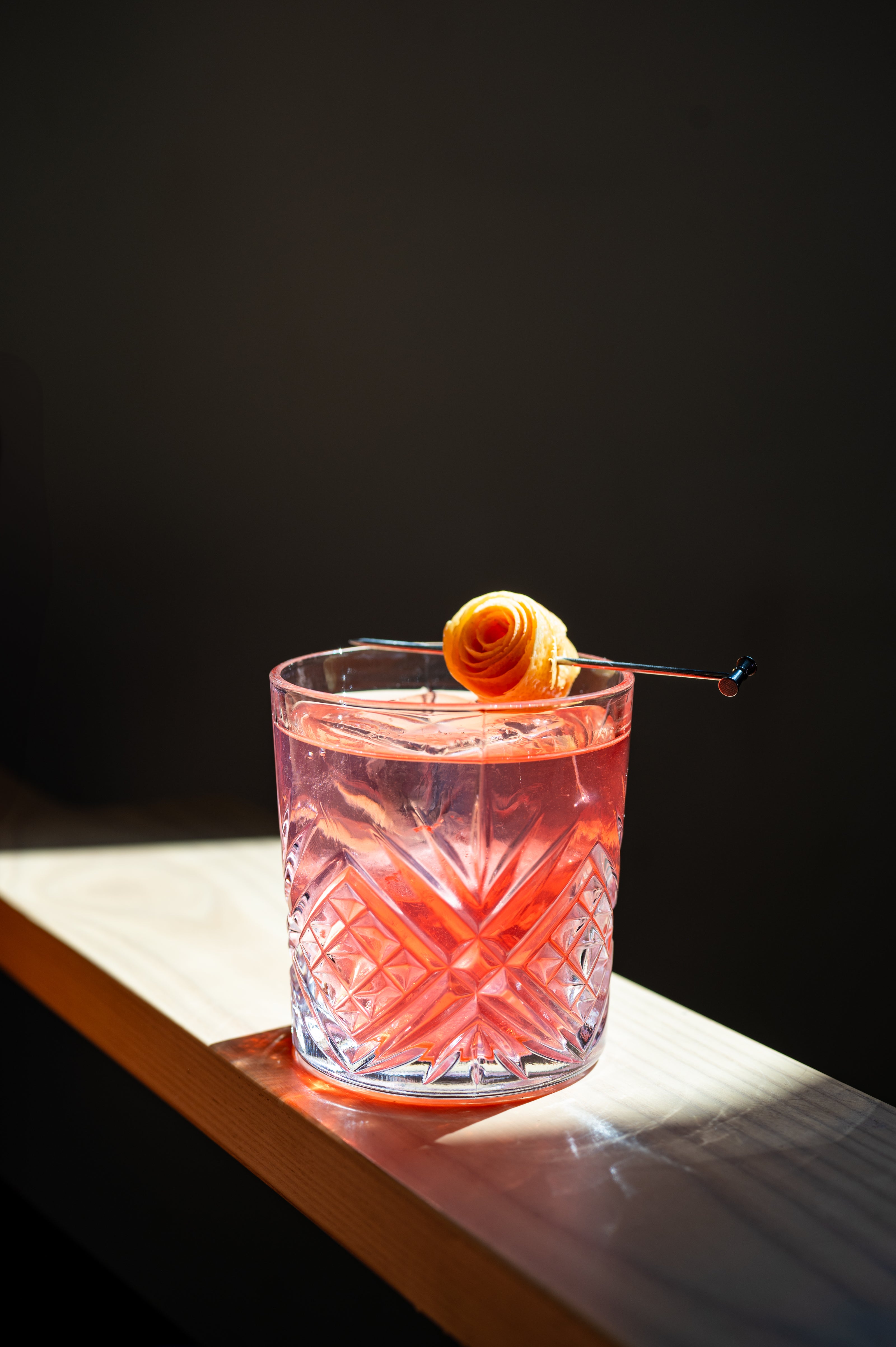 cocktail with orange twist in a high contrast light