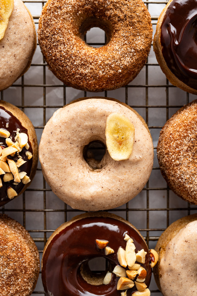 flatlay of various flavors of banana donuts on a cooking grate